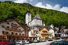 105711_Hallstatt Markt Hotels & Wohnhuser Foto unter kath. Pfarrkirche am grnen Berghang in Frhling