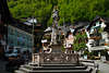 105717_Markt Panorama Foto von Hallstatt alte Salzstadt Reisebilder Huser Cafs grn Waldhang Brunnen Denkmal
